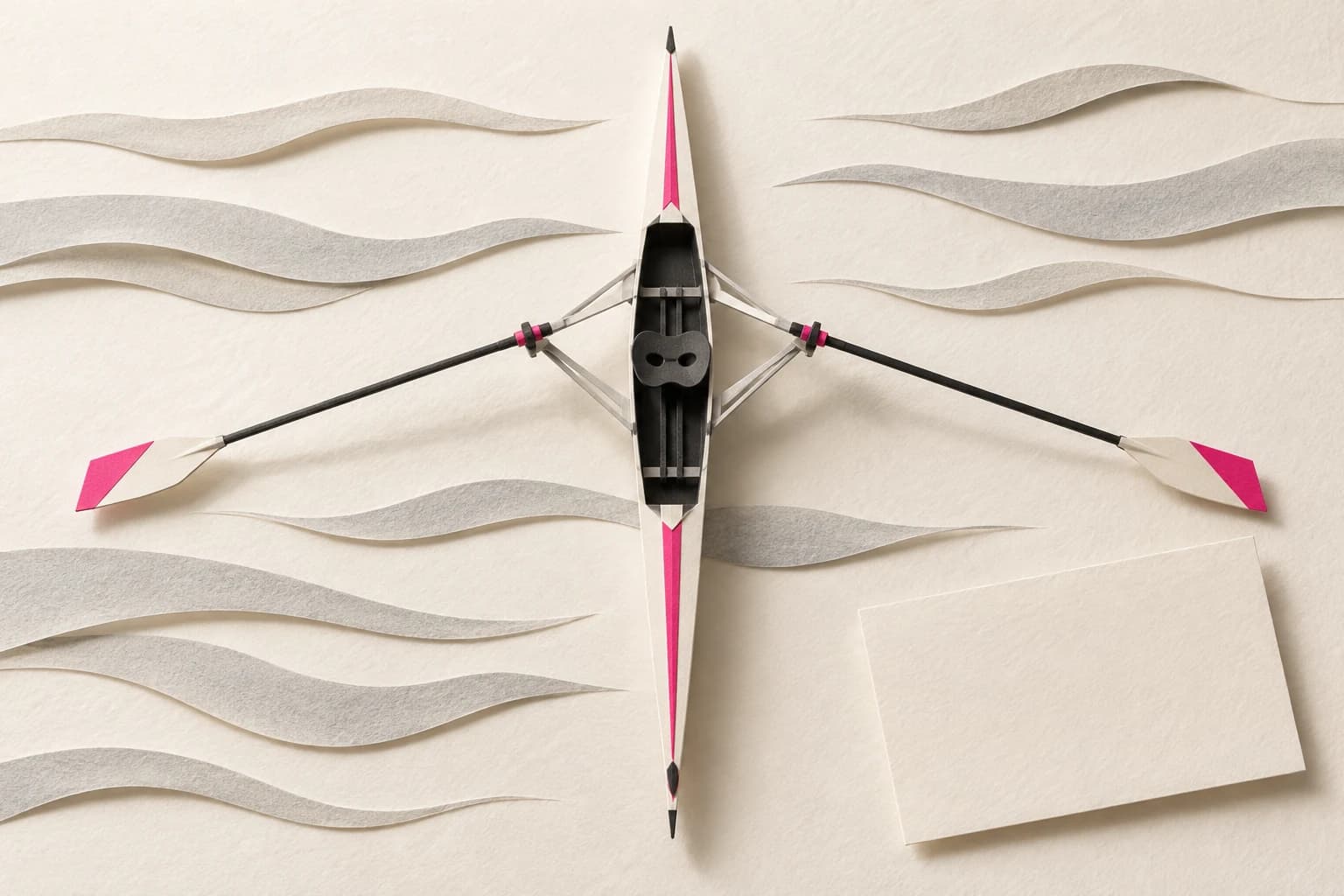 A slender paper rowing shell with two sculling oars sits alongside parallel water ripples.