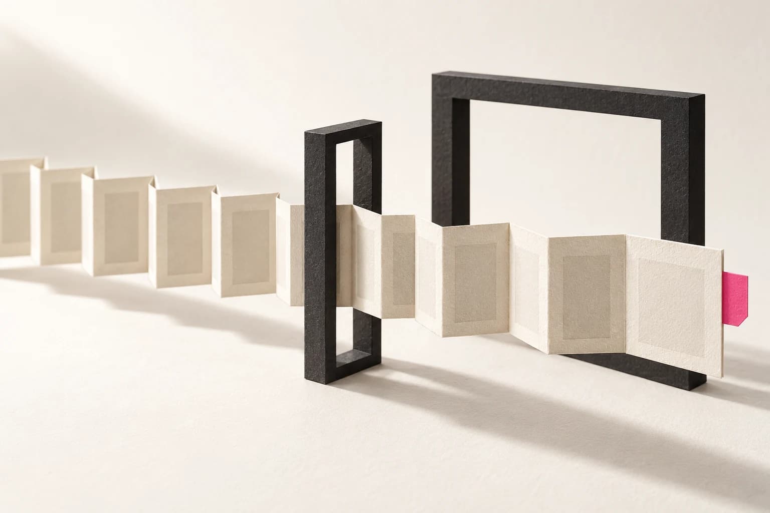 A wide folded paper sheet passes through a narrow upright frame beside a wider frame.